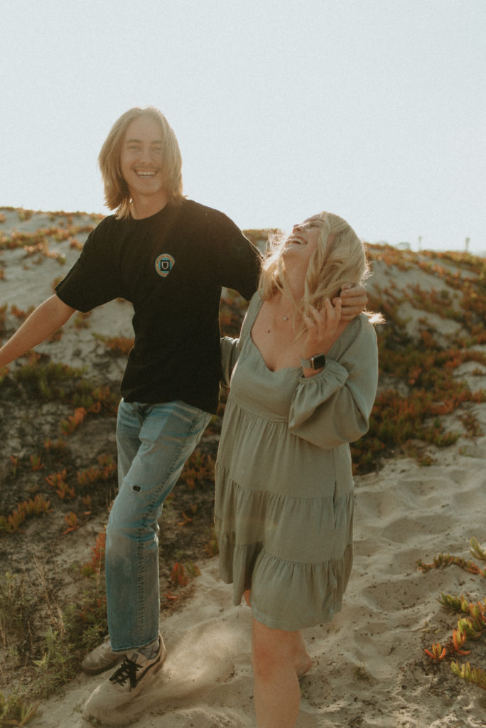 engagement photo of couple laughing at the beach